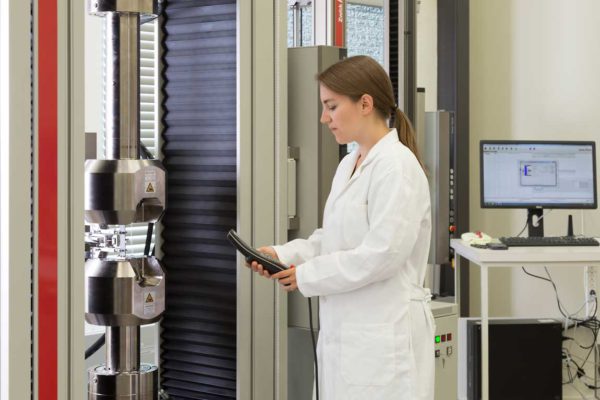 woman in lab coat examining machine